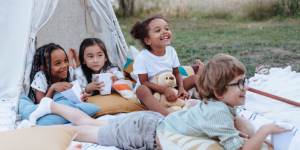 Photo of children outside, hanging around a decorative tent