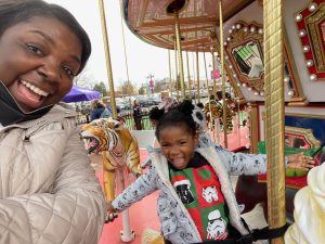 Coretta Walker and daughter on a carousel